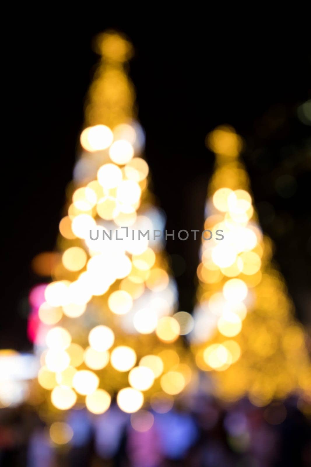 Conceptual background image of defocused abstract Christmas Tree on city street at night