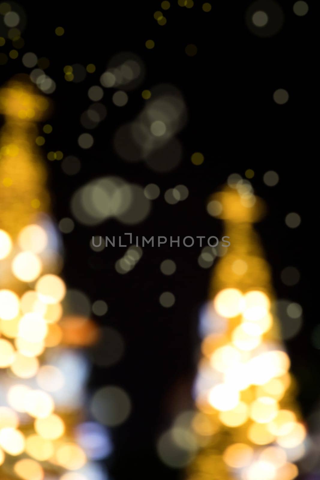 Conceptual background image of defocused abstract Christmas Tree on city street at night