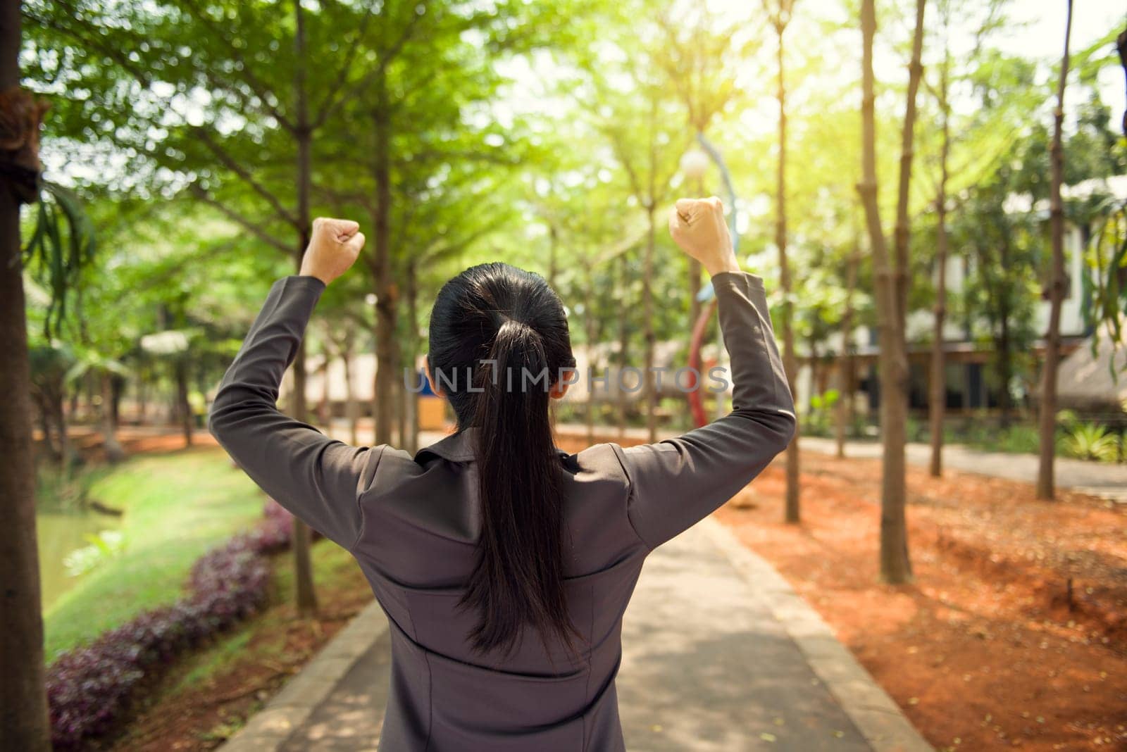 Rear view of successful asian business woman standing outside the office room