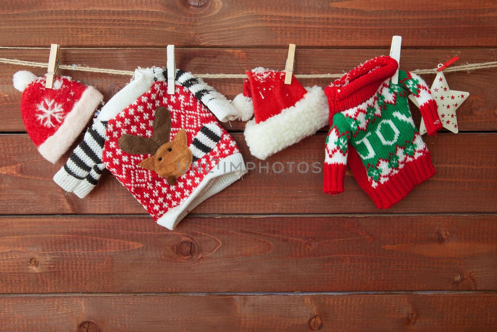 Little knitted christmas pullovers on a wooden background