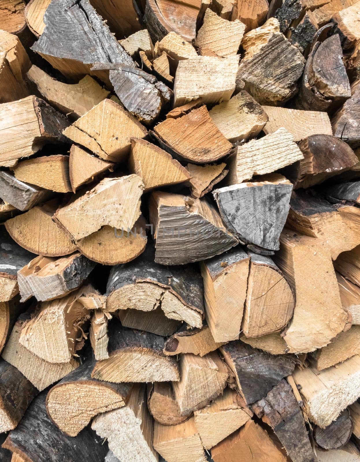 Background of dry chopped firewood. Stock pyre dry for fuel. They use for cook and make heat when cold weather.