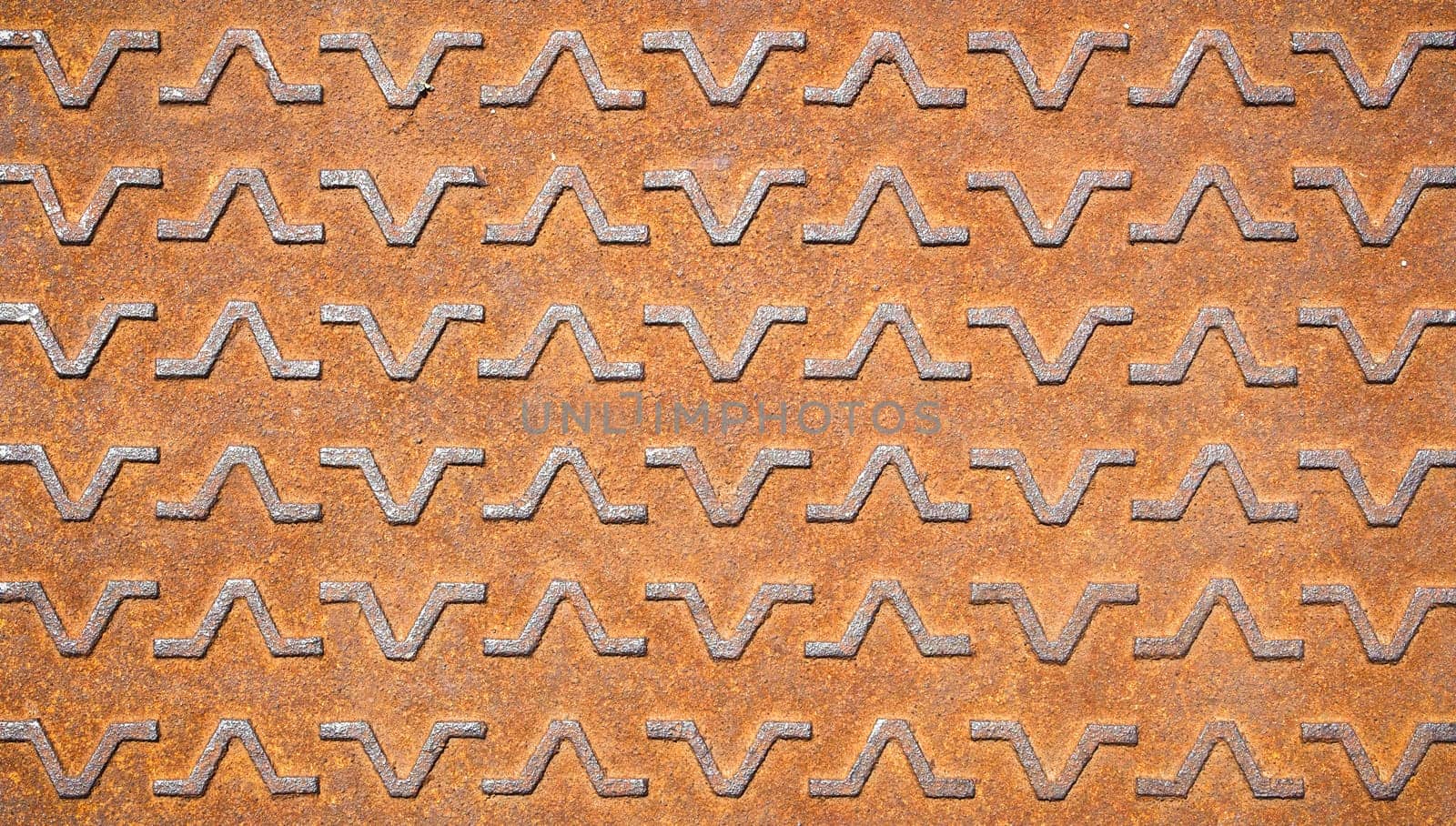 Background with metallic textures pattern. Close-up of a rusty manhole.
