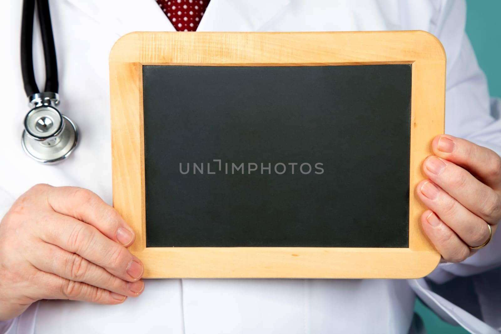 Doctor holding blank chalkboard in Detail