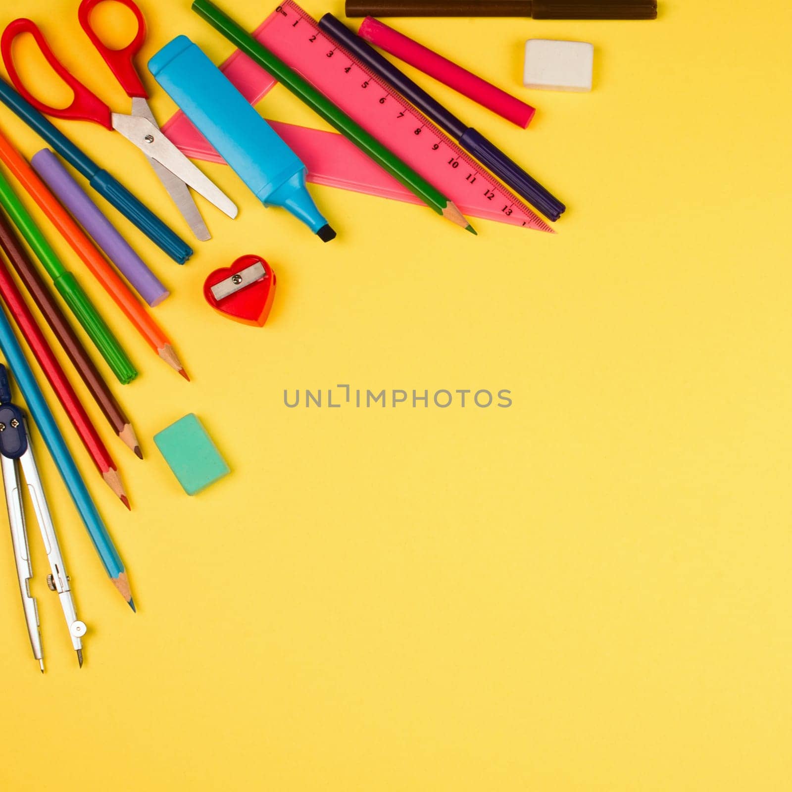 Different school supplies are on yellow background.