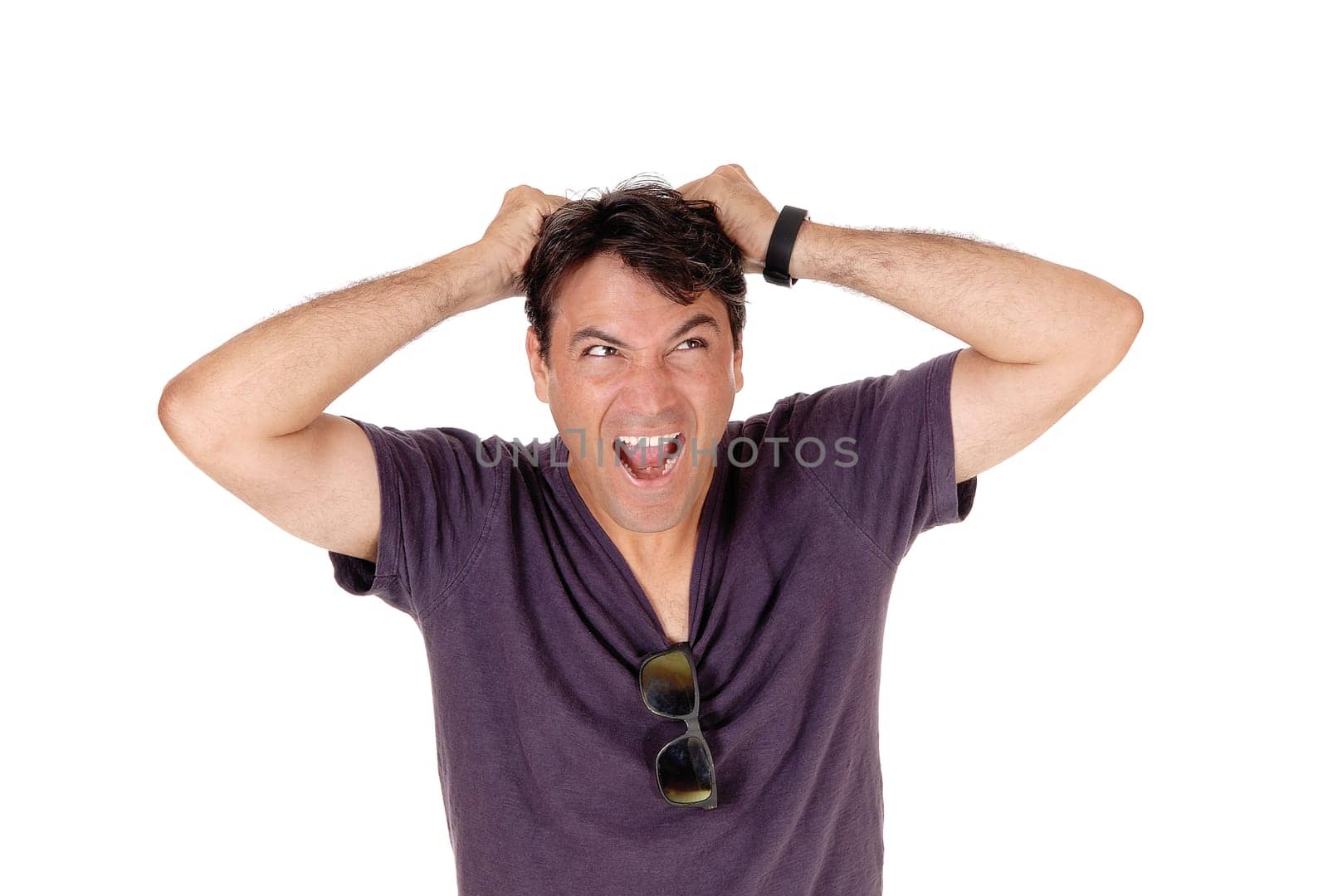 A tall man in a burgundy shirt screaming and messing up his hair.with his mouth open, isolated for white background.