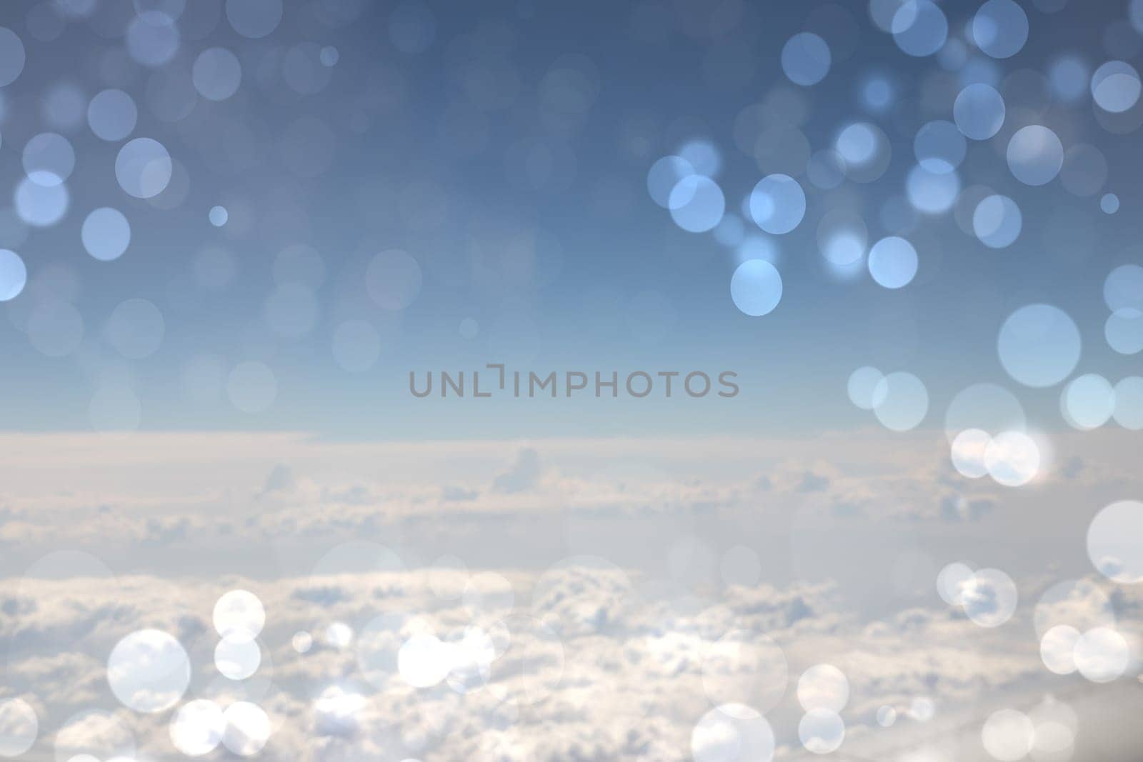 Beautiful abstract bright blue cloudy sky texture with bokeh circles. Space for text.