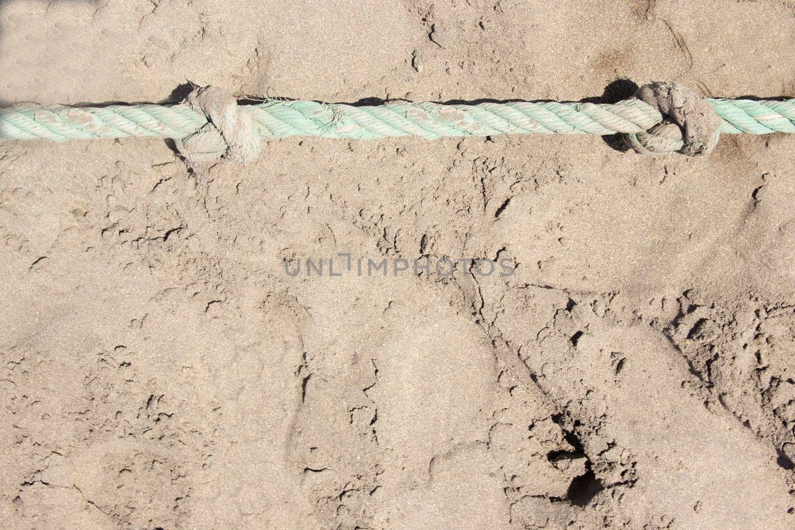Close-up of rope knots on sand beach. Safety concept coast.