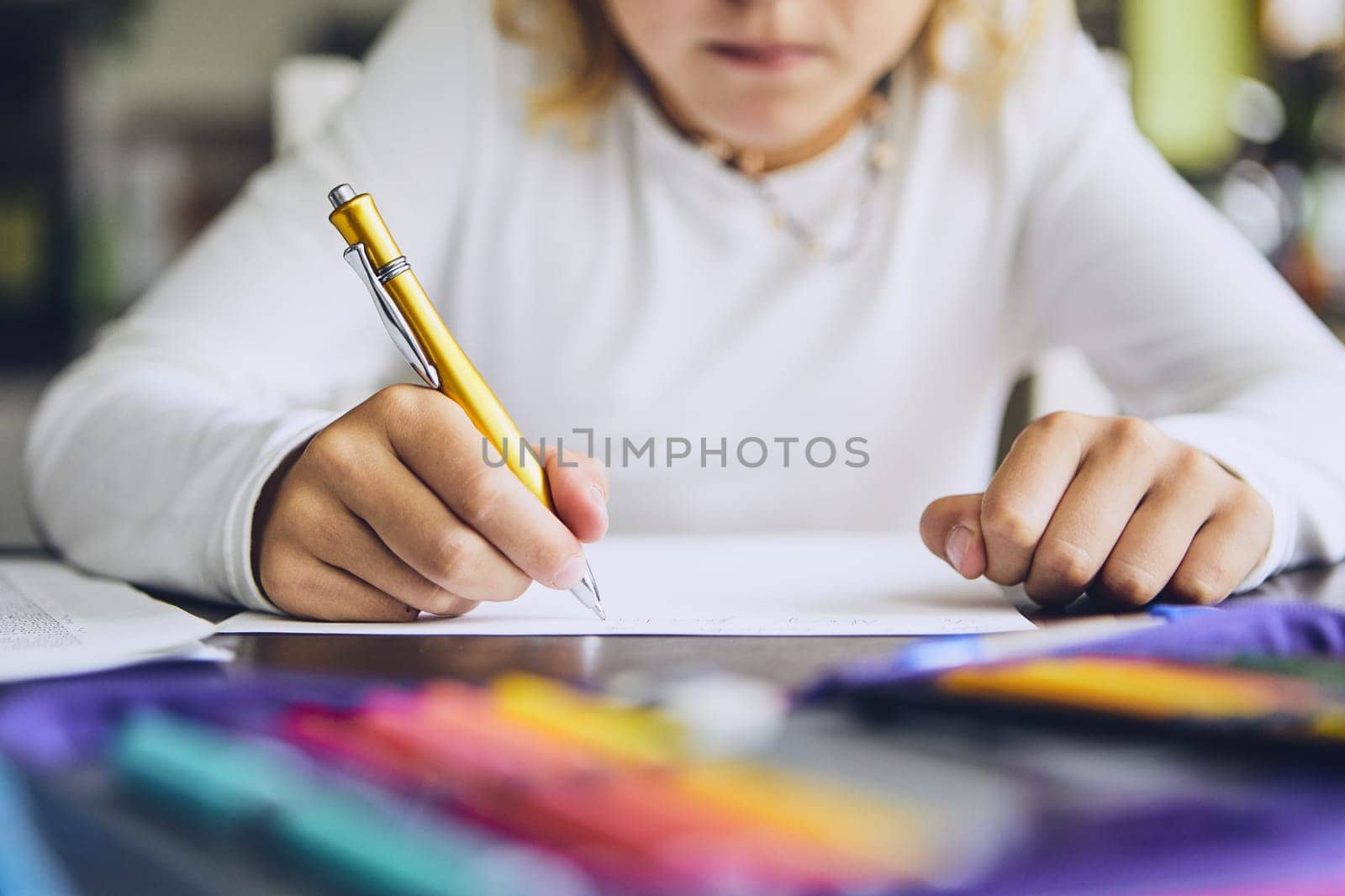 Cute girl writing her homework for elementary school at home.