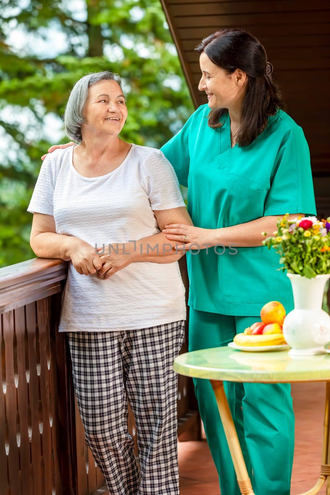 Senior woman with her home caregiver spending time together. Female nurse consoling senior woman at home.