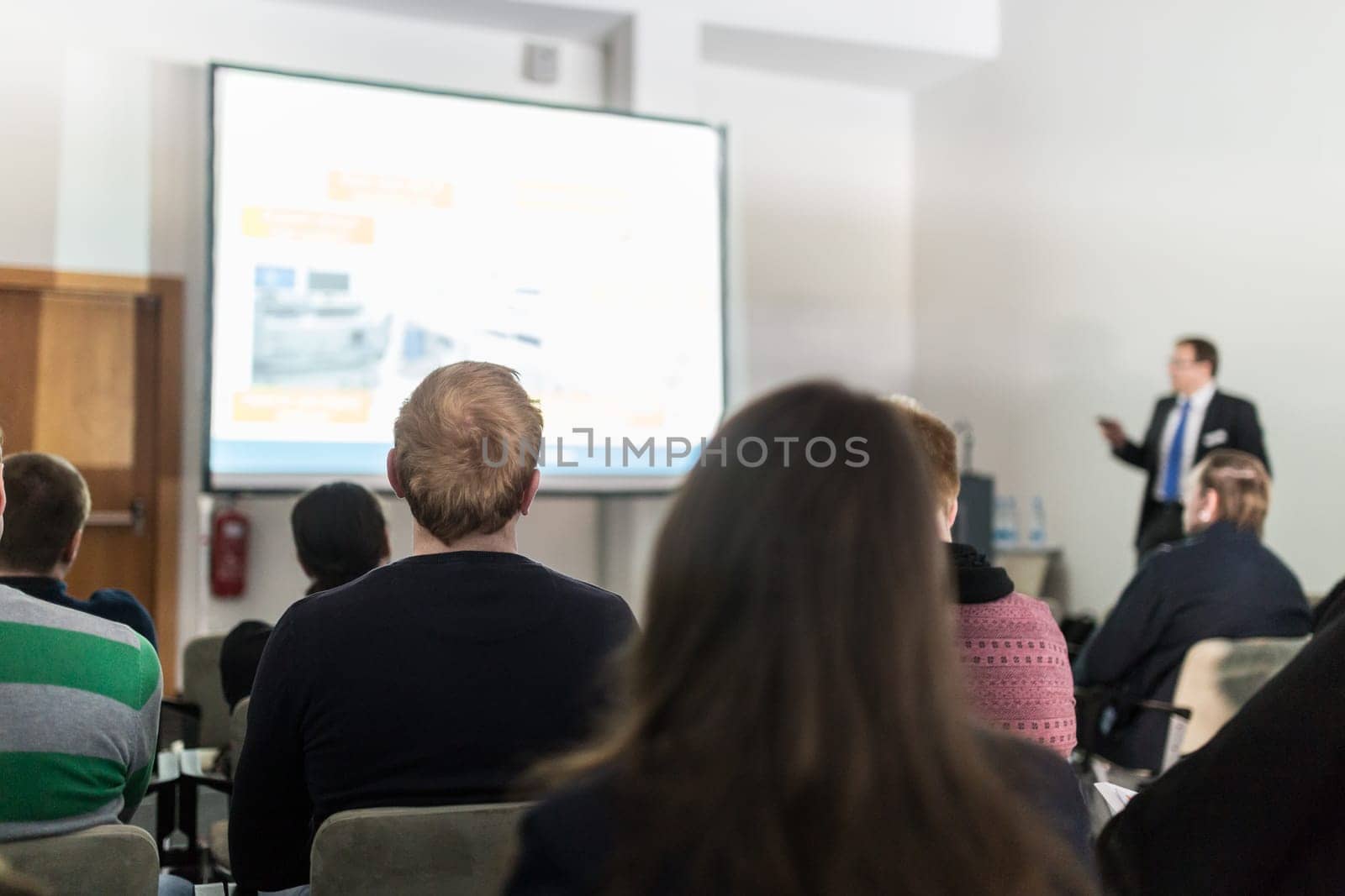 Speaker giving a talk in conference hall at business event. Participant from the audience asking a question. Audience at the conference hall. Business and Entrepreneurship concept.
