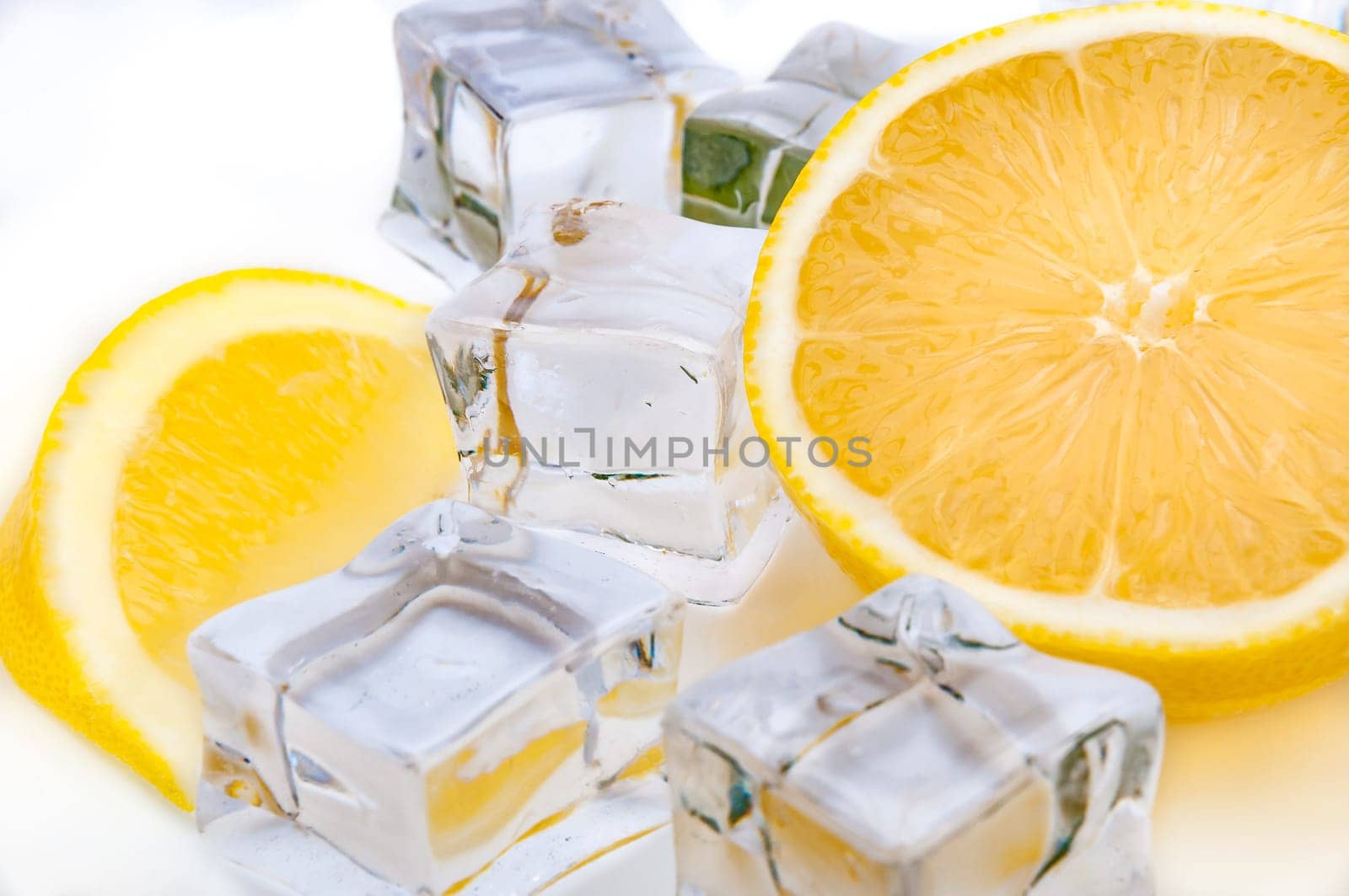 Half a juicy bright lemon and refreshing ice cubes close-up