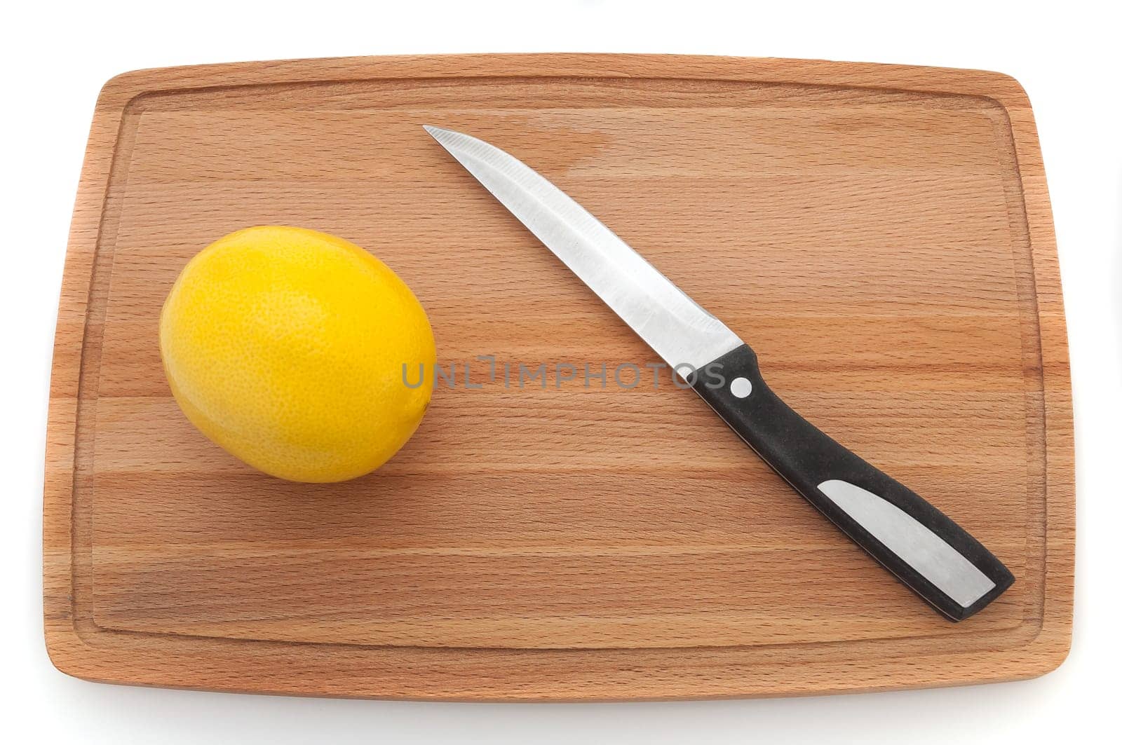 bright fresh lemon with a knife on a wooden board.