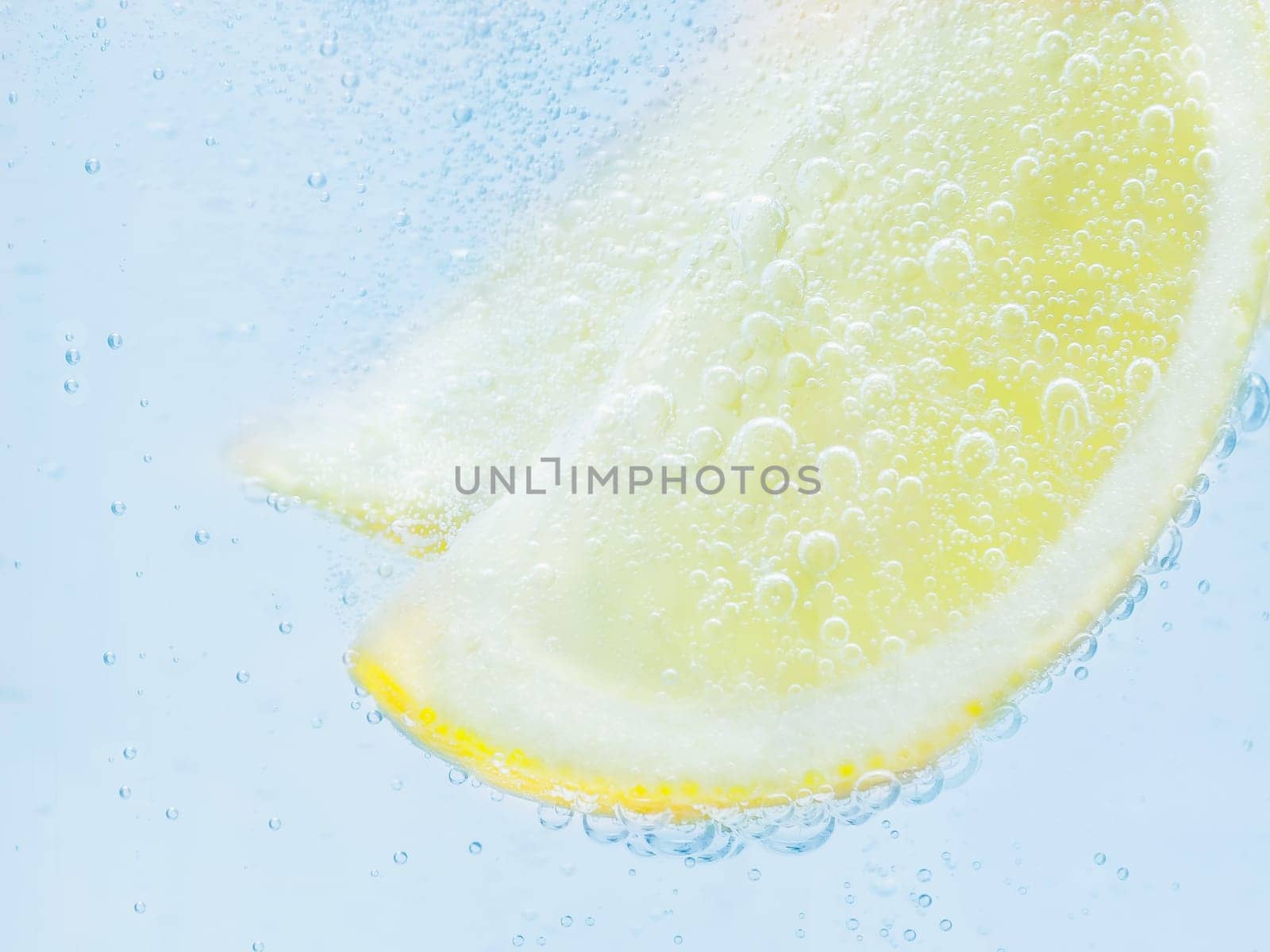 slices of fresh juicy yellow lemon in soda.