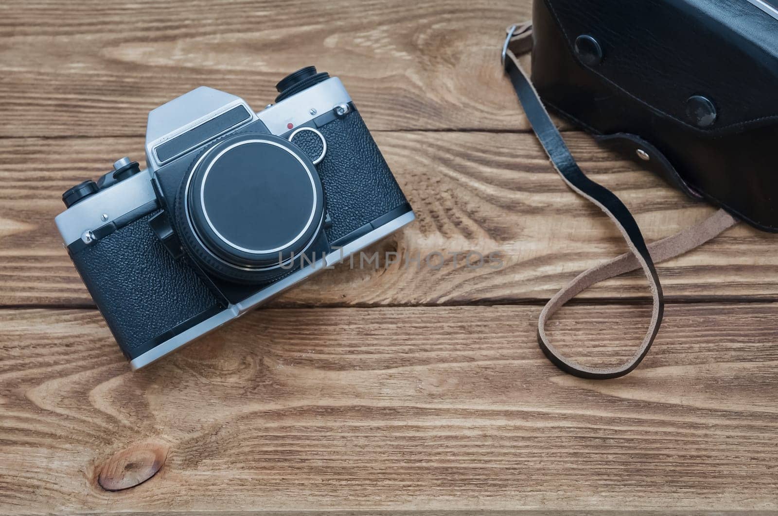 Vintage old camera on textured boards table.