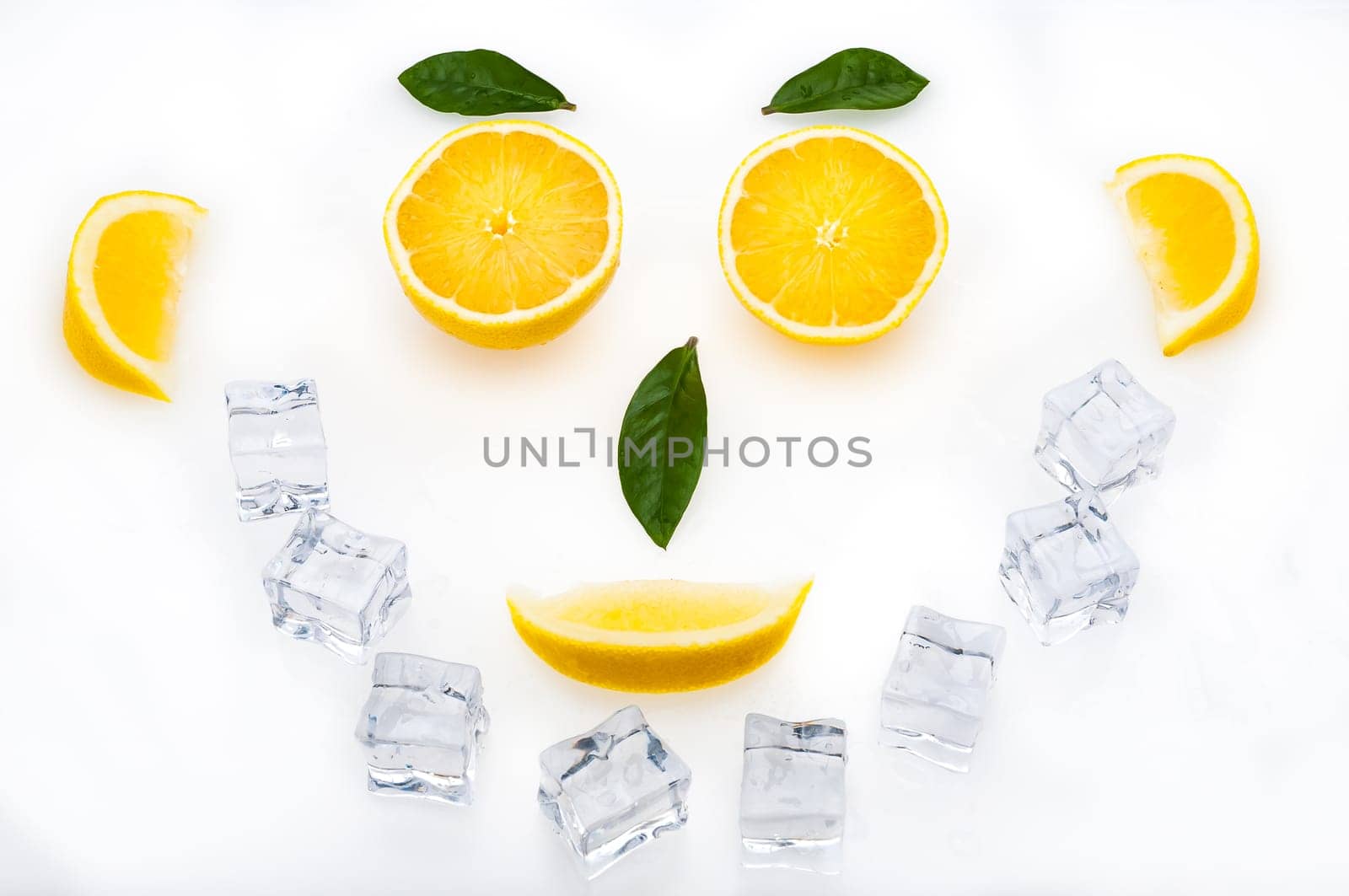 Bright lemon slices, green leaves and ice cubes in the shape of a face. healthy lifestyle.