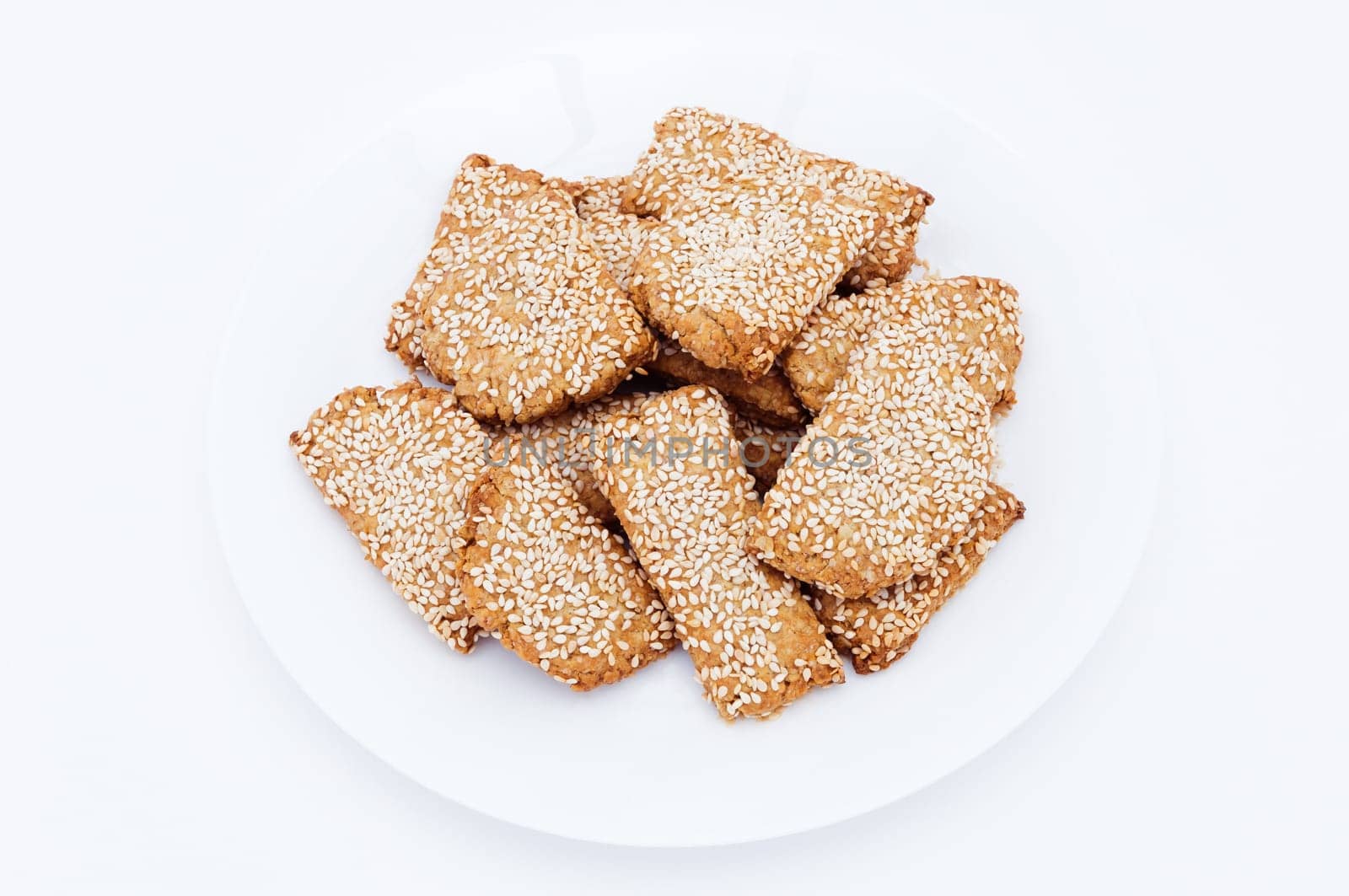 Homemade cookies with sesame on a white plate.