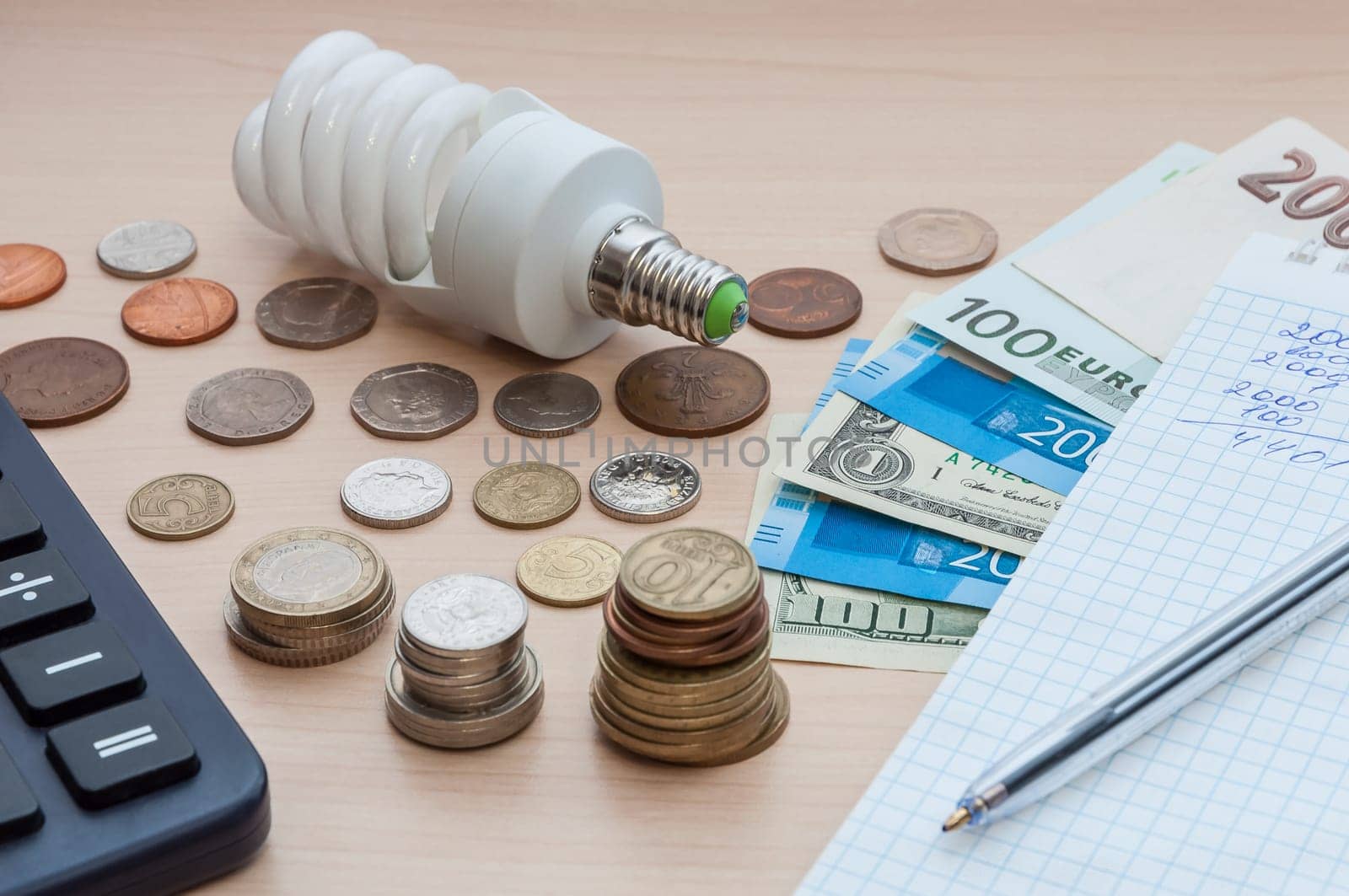 A light bulb, a notebook with a pen, bills, various money and a calculatore.