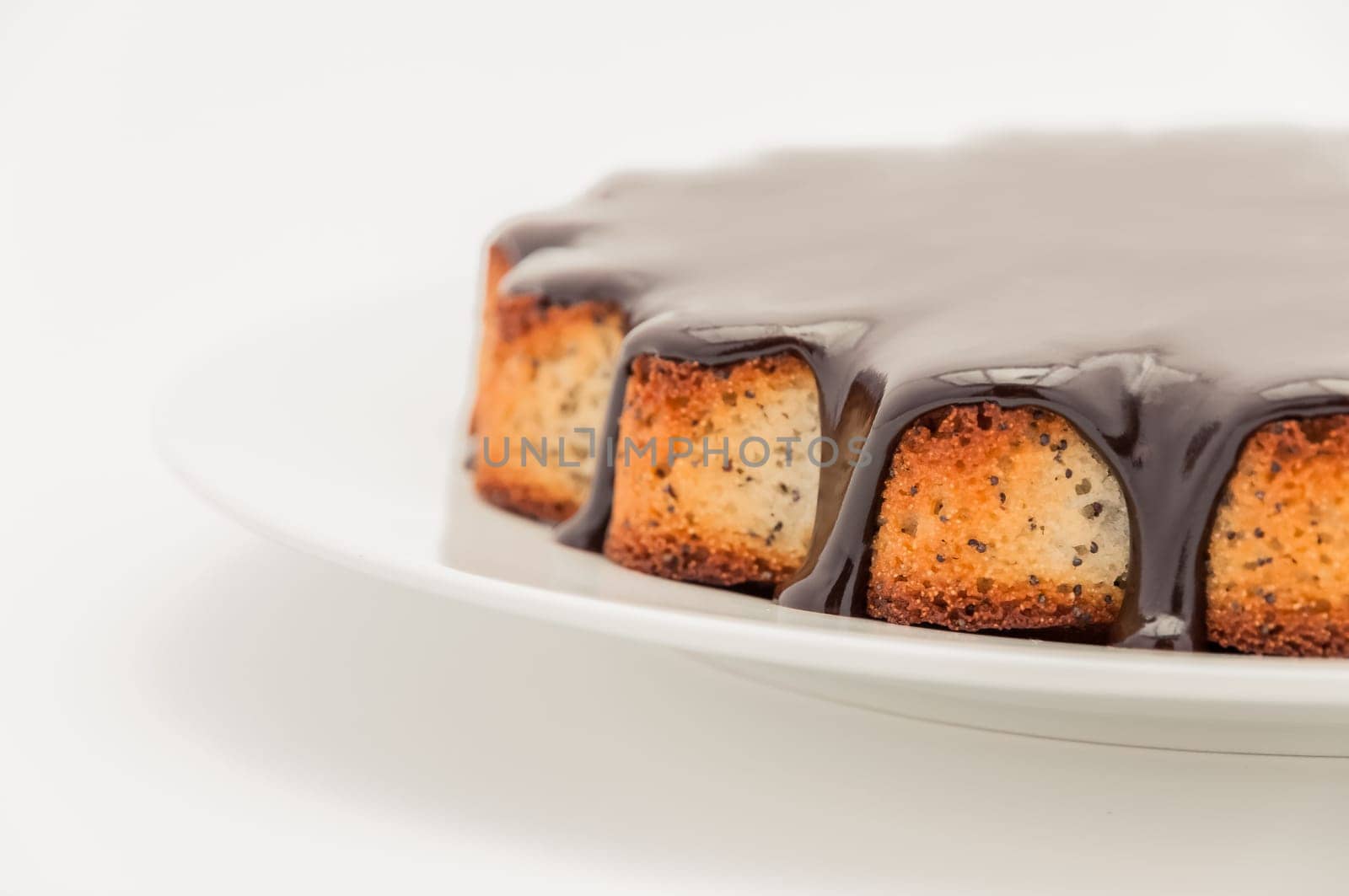 Half a cake with chocolate covered in a plate on a white background on the right. Isolated.