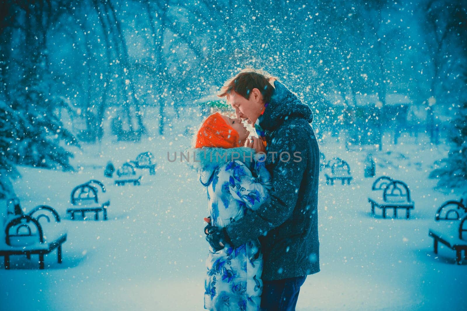 beautiful young couple kiss on snow park background