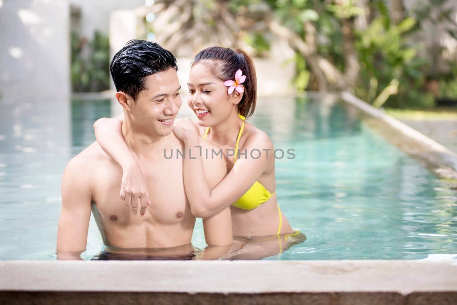 Portrait of asian couple enjoy relaxing time on the swimming pool