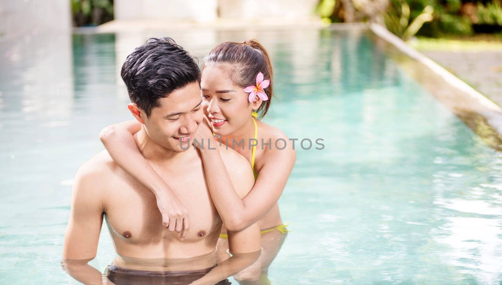 Portrait of asian couple relaxing in swimming pool