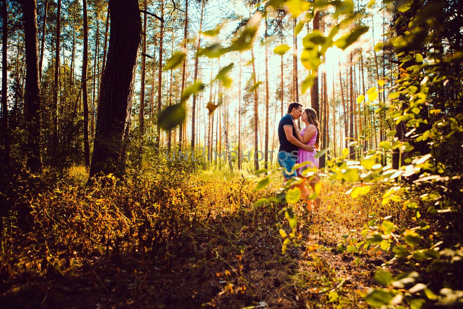 Romantic young couple kissing on background summer forest