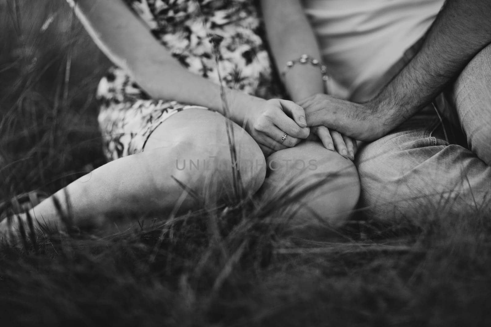 Romantic black white photo couple sit on background summer meadow sunset