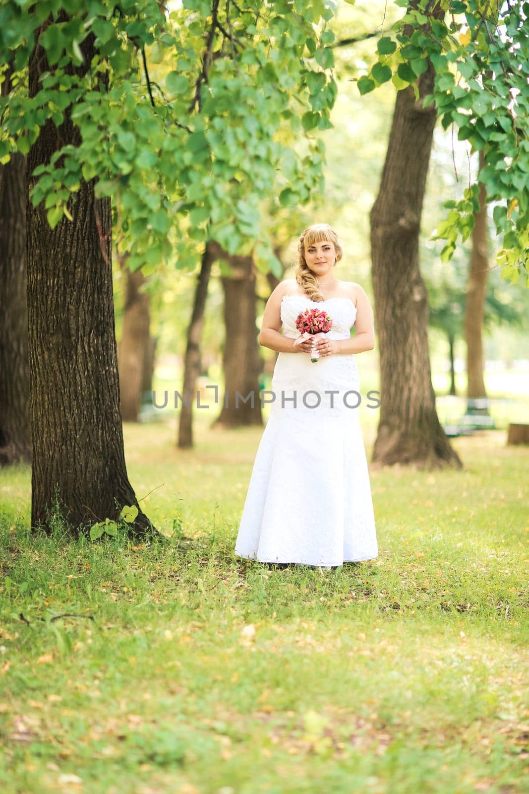 beautiful young bride stand on background forest