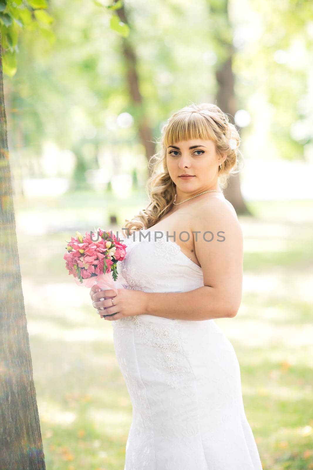 beautiful young bride stand on background forest