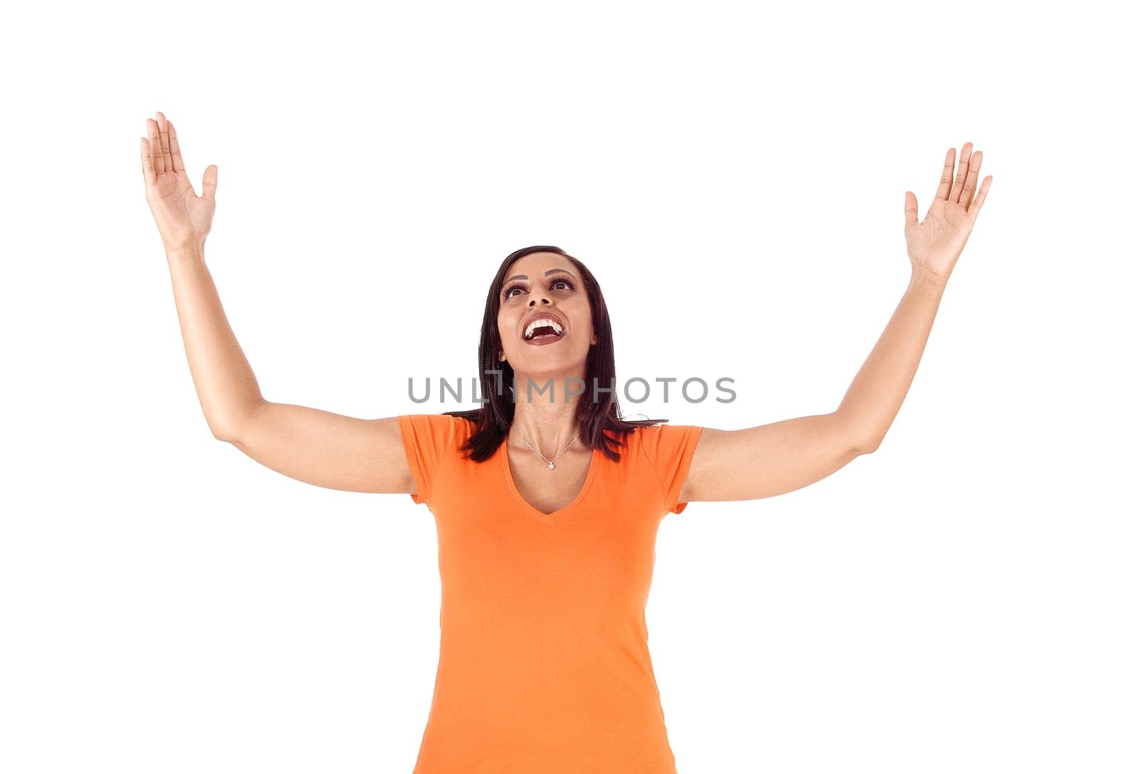 A young happy woman standing in a pink top with her arms raised.and open mouth laughing, isolated for white background.
