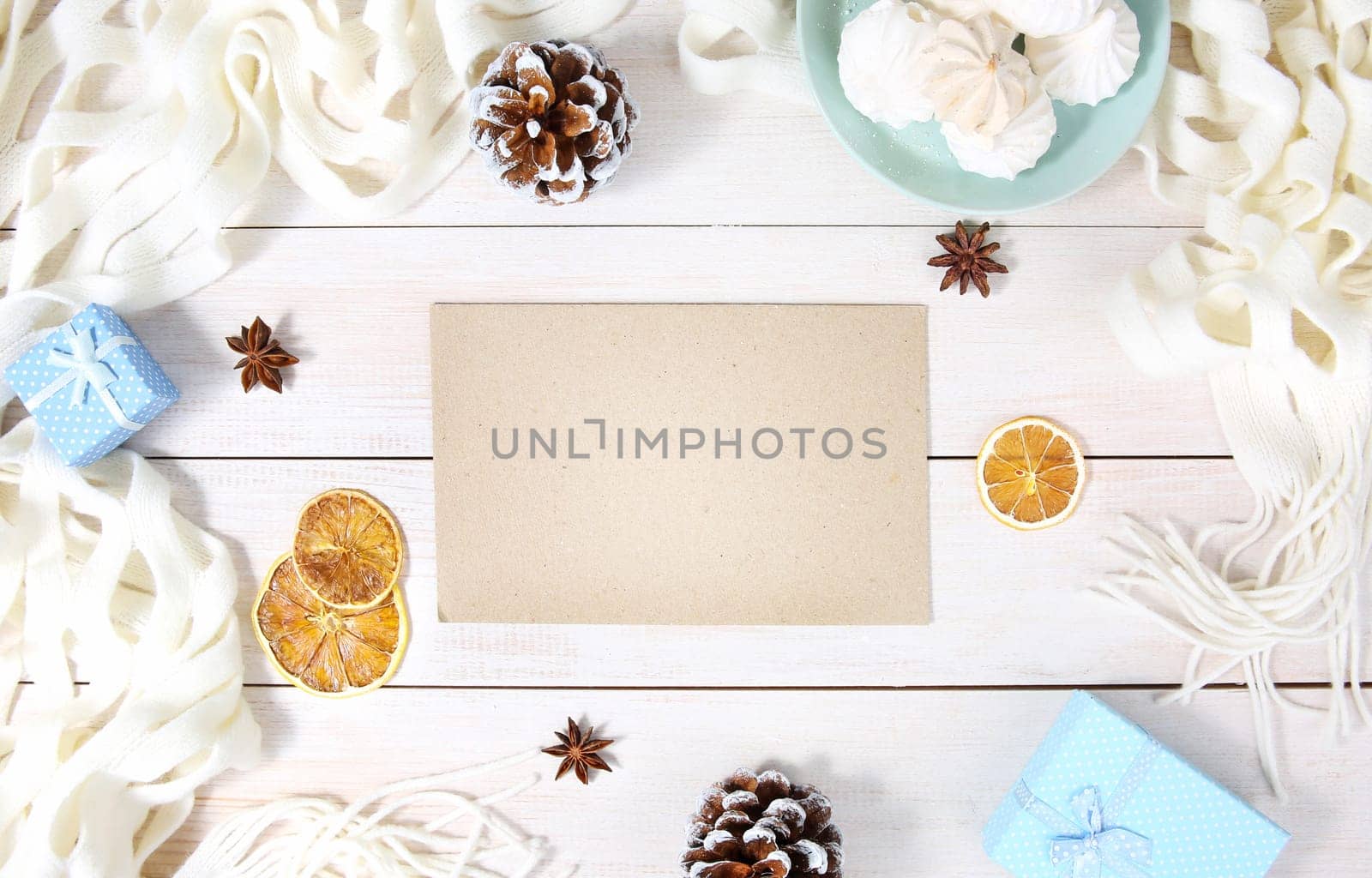 Autumn or winter composition with top view on paper sheet, white scarf, gift box and other winter accessories. Copy space blank sheet.