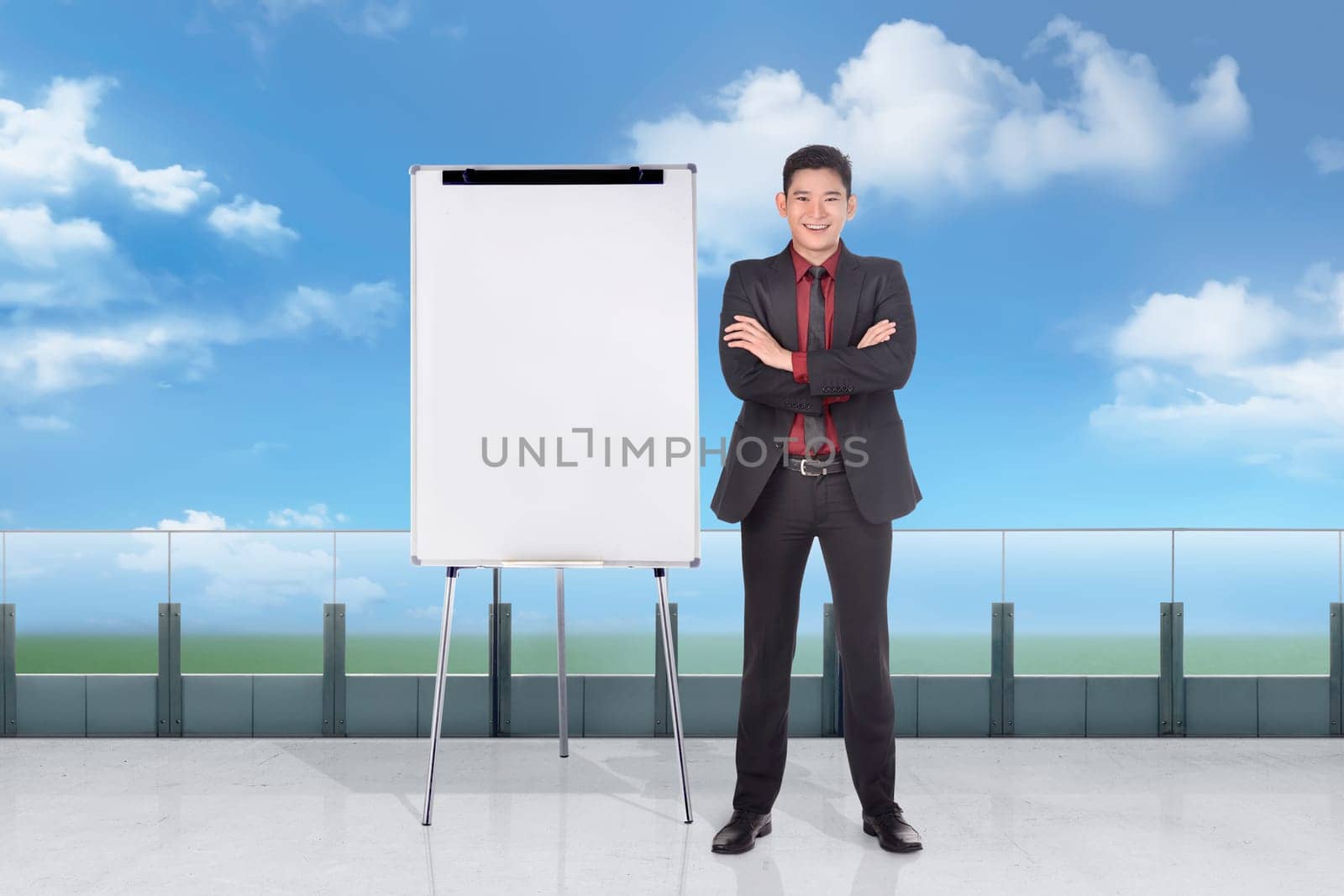 Handosme asian businessman standing with empty whiteboard outside office room