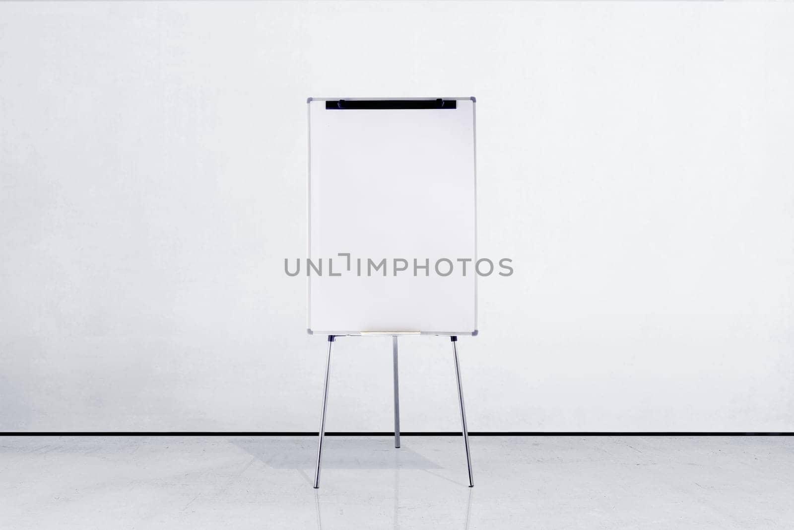 Standing white board inside room with white wall background