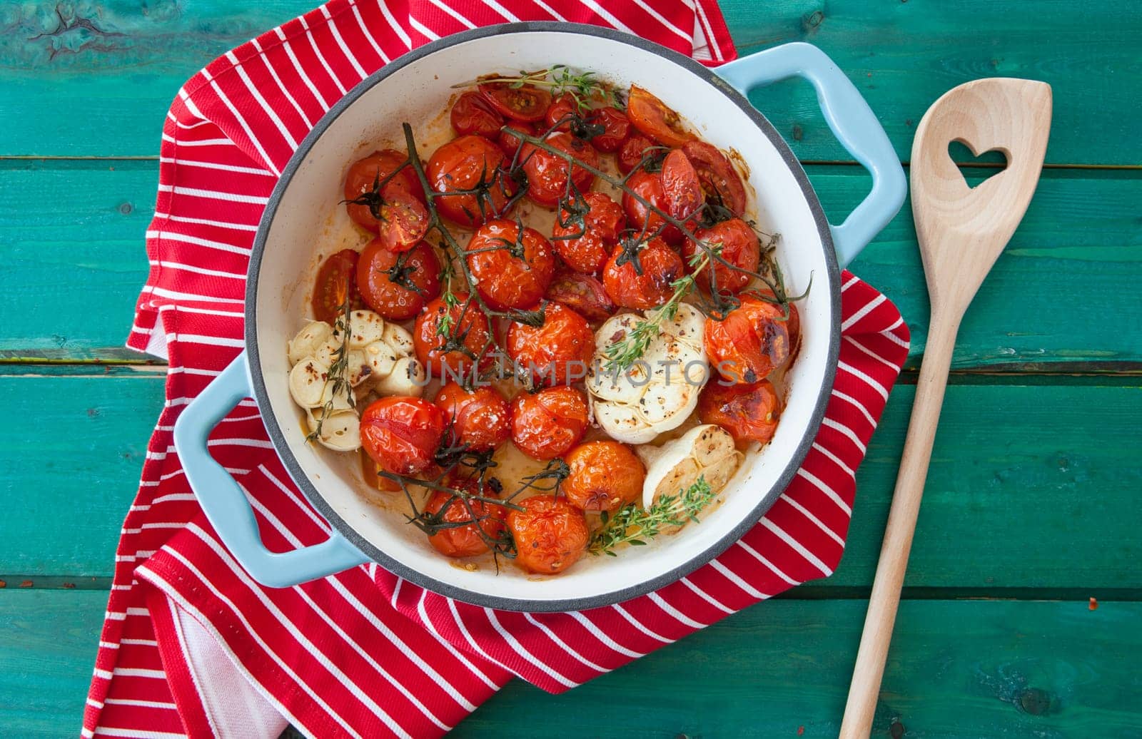 Roasting vine tomatoes with garlic and thyme in a pan