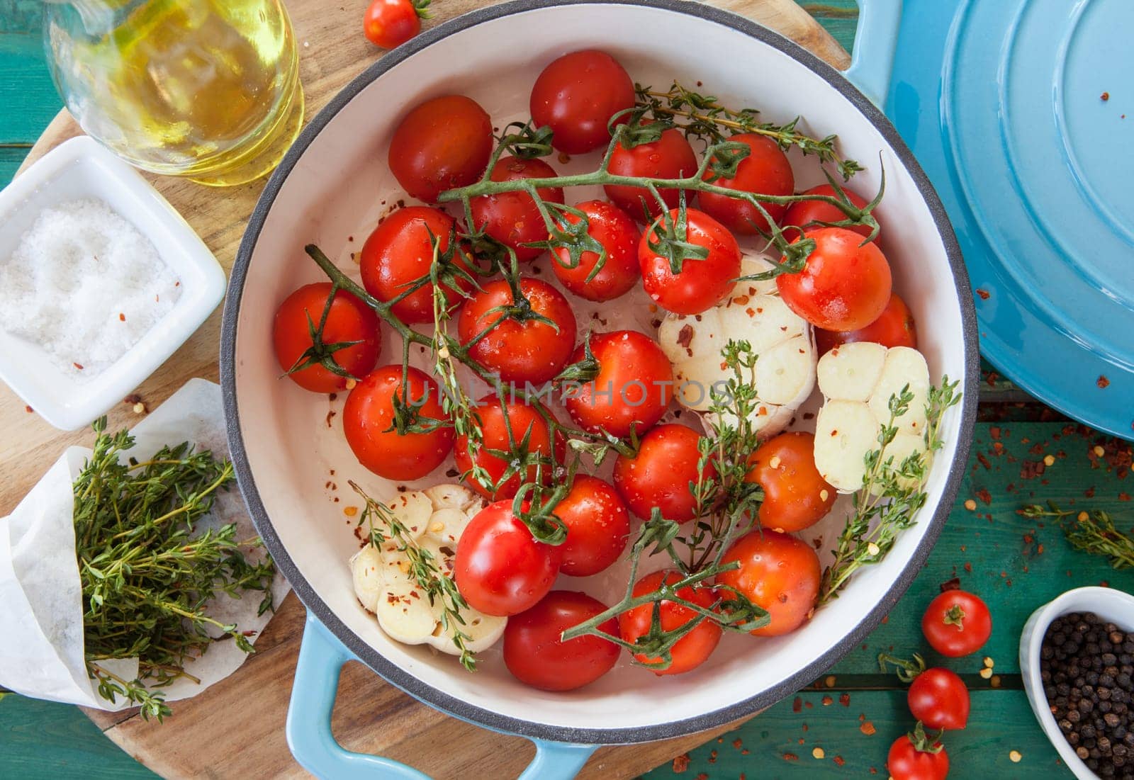 Roasting vine tomatoes with garlic and thyme in a pan