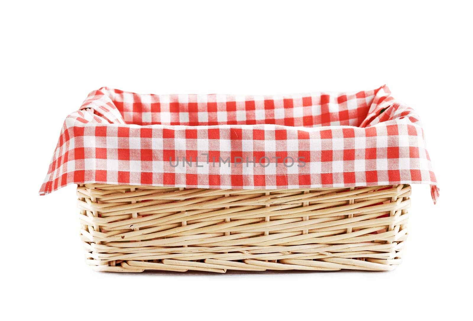 Empty straw basket with checkered red linen napkin isolated.