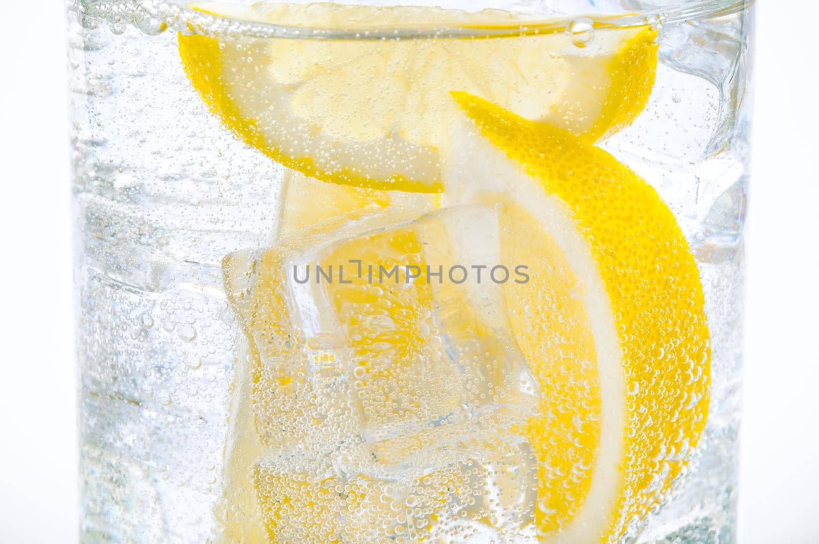 Ice, lemon slices and clear water in a glass.