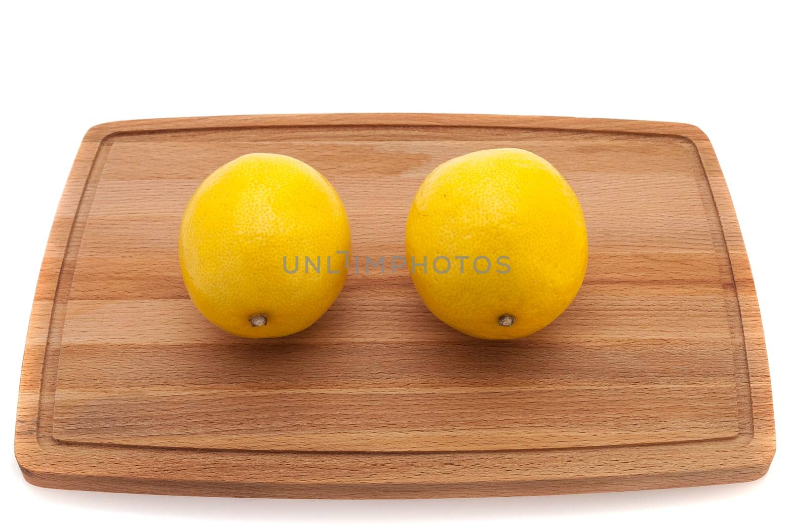 two yellow bright juicy lemon on a cutting board