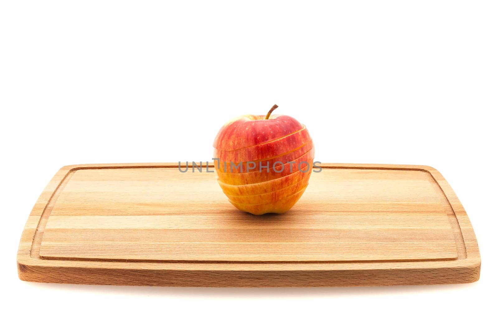 Red and yellow apple sliced on a cutting board