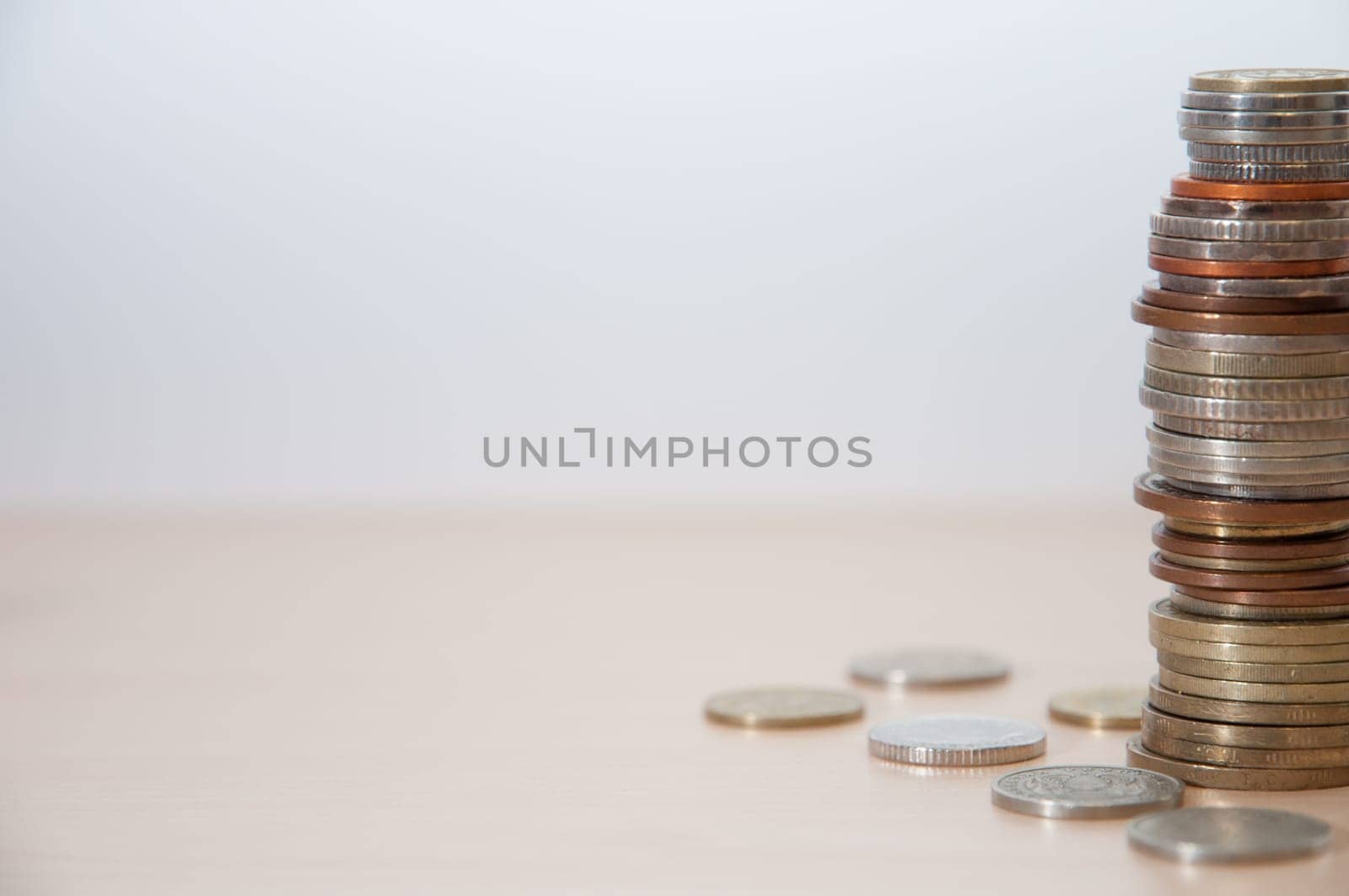 A stack of coins of different countries, color, dignity and size on the right at the edge.