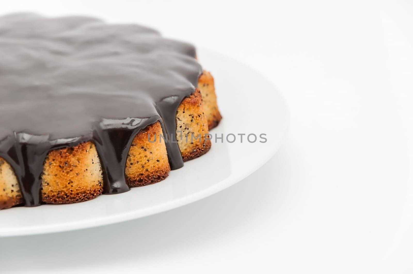 Half of a manga cake with chocolate sprinkled on a plate on a white background on the left.