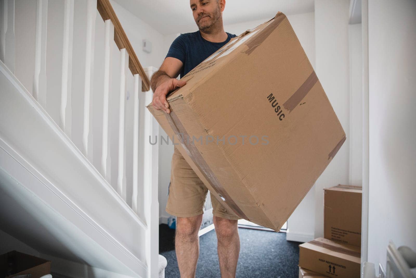 Mature man is moving boxes of belongings in to his new home.