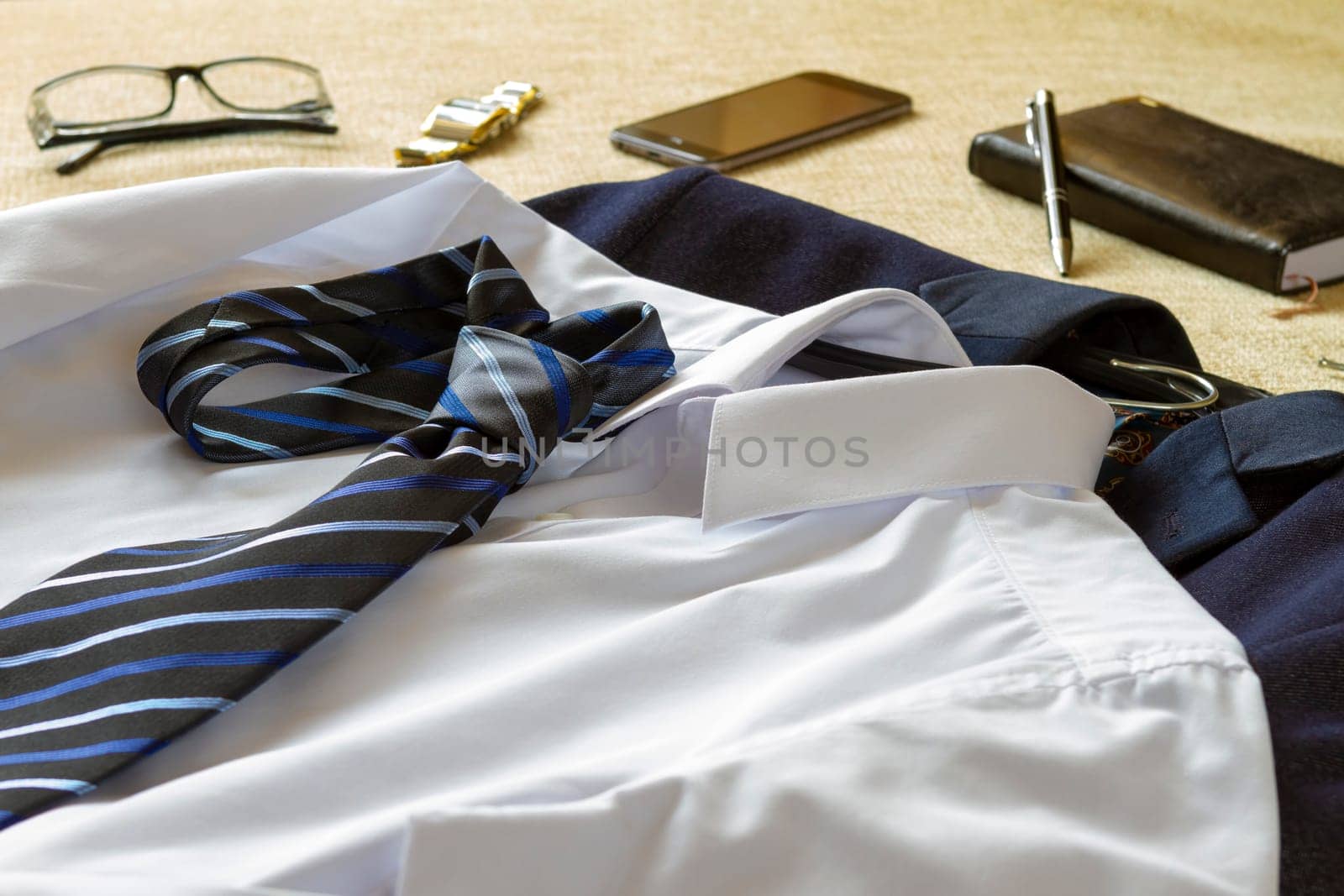 Business man clothes accessories and smartphone on bed. Business man preparing to go at office concept.