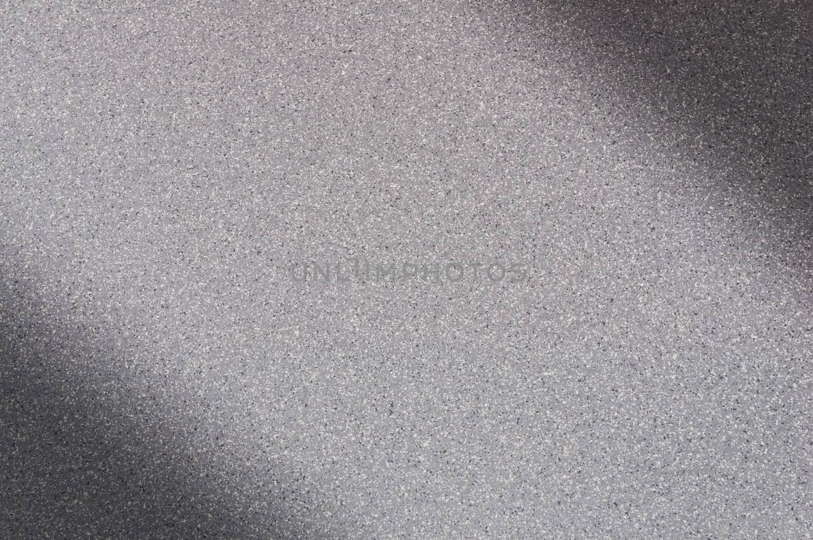 Granite background of gray color with small dots. Darkening left and right diagonally. Blurred.