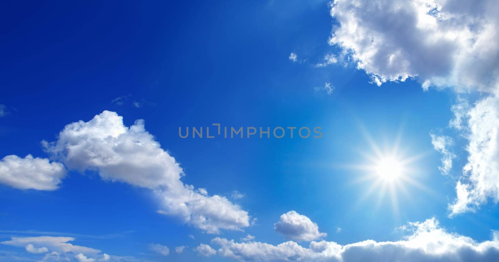 conceptual background image of blue sky with clouds and shining sun