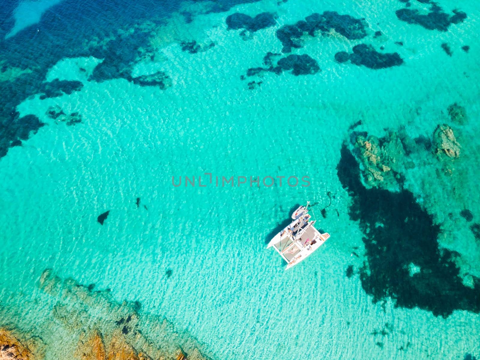 Drone aerial view of catamaran sailing boat in Maddalena Archipelago, Sardinia, Italy. Maddalena Archipelago is a group of islands between Corsica and north-eastern Sardinia.