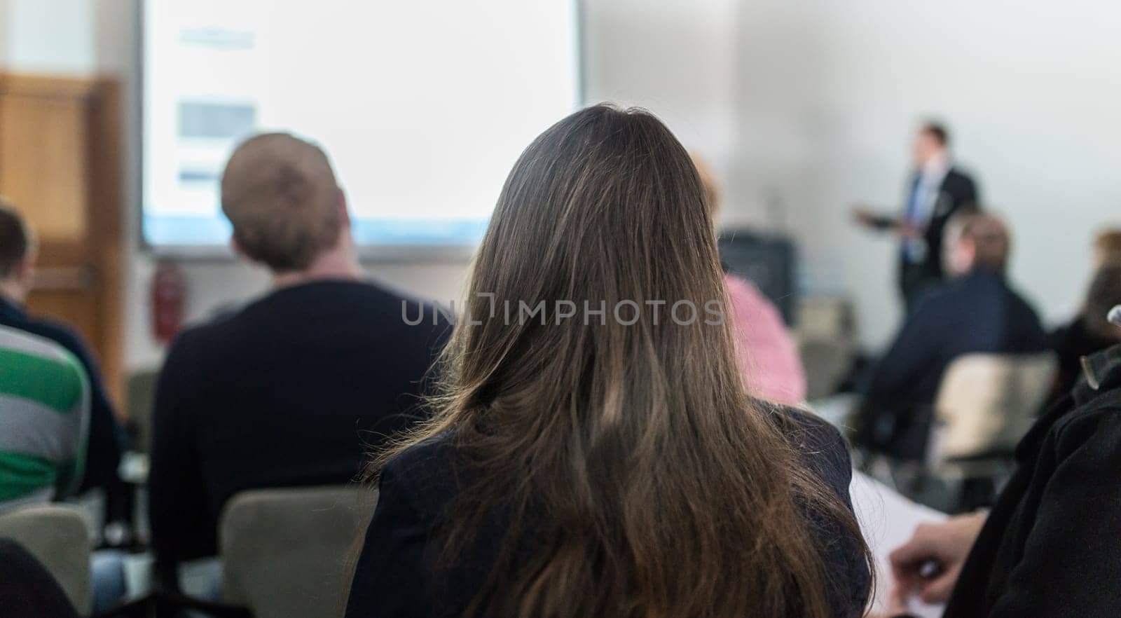 Speaker giving a talk in conference hall at business event. Participant from the audience asking a question. Audience at the conference hall. Business and Entrepreneurship concept.