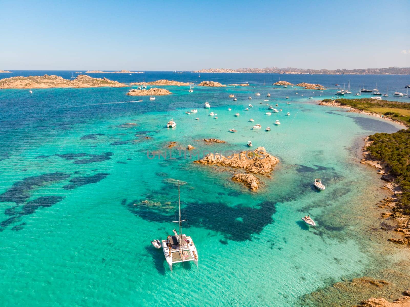 Drone aerial view of catamaran sailing boat in Maddalena Archipelago, Sardinia, Italy. Maddalena Archipelago is composed of Razzoli, Santa Maria and Budelli islands.
