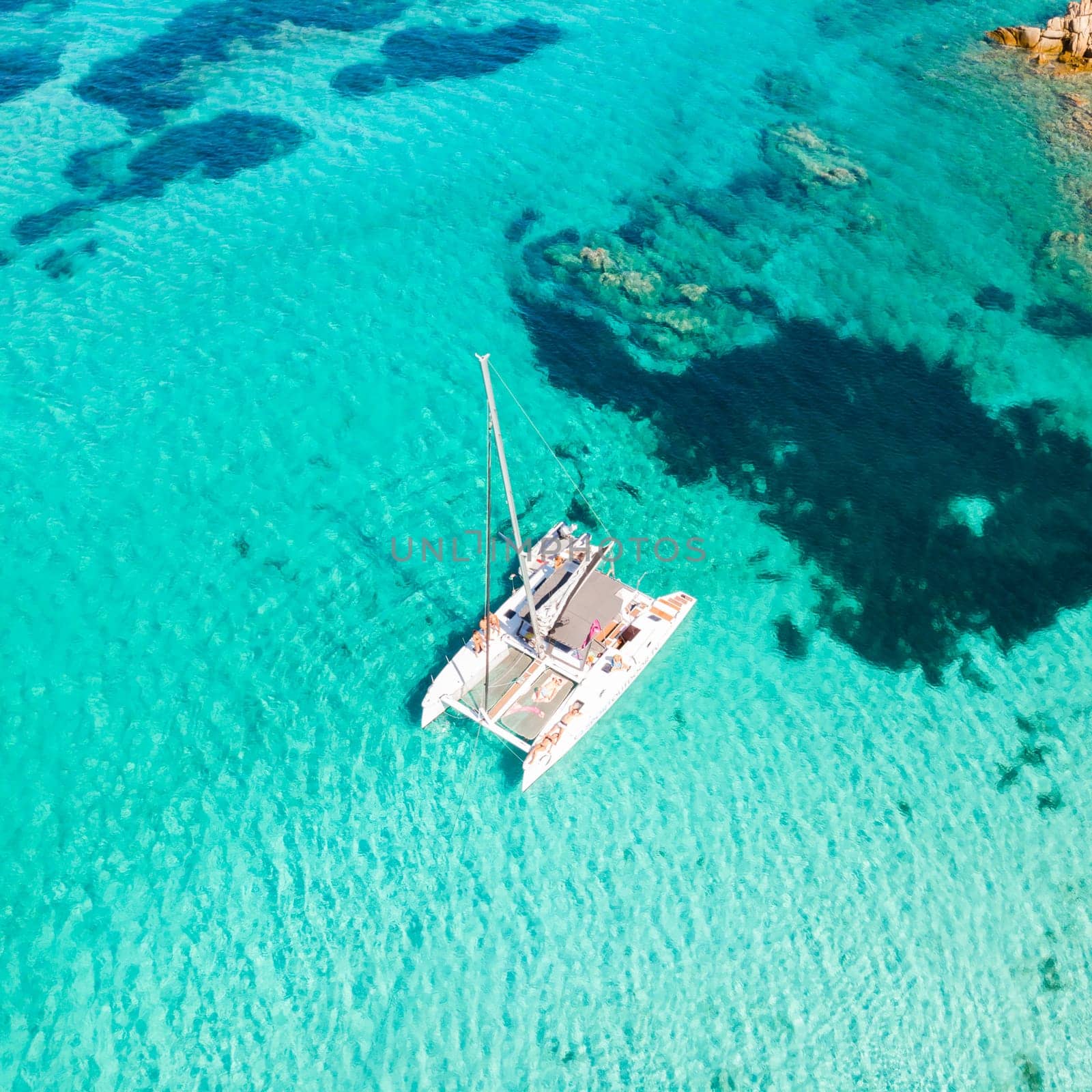 Drone aerial view of catamaran sailing boat in Maddalena Archipelago, Sardinia, Italy. Maddalena Archipelago is a group of islands between Corsica and north-eastern Sardinia.