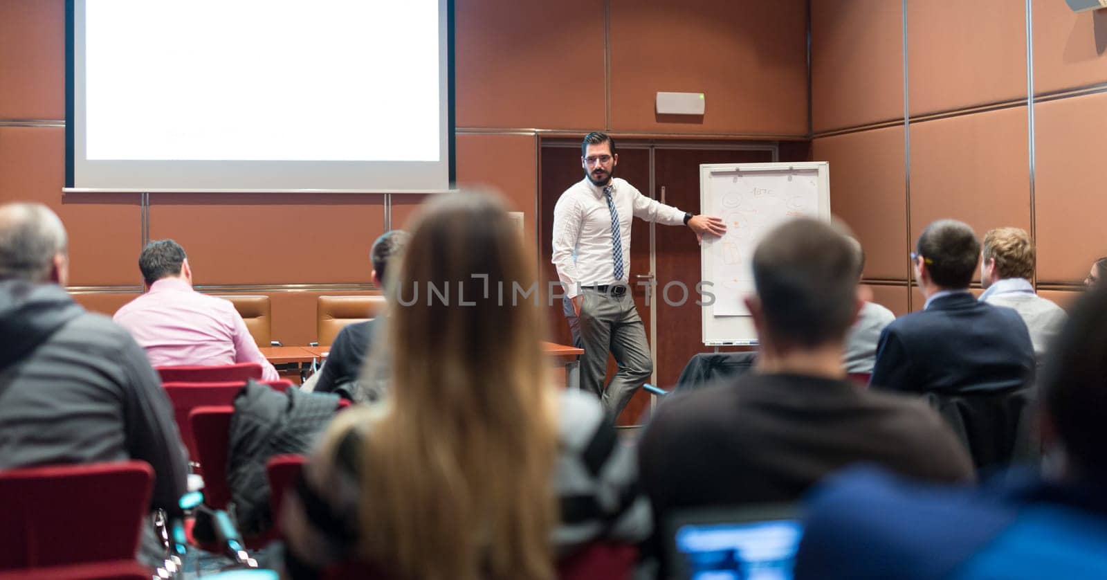 Speaker Giving a Talk at Business Meeting. Audience in the conference hall. Business and Entrepreneurship concept.